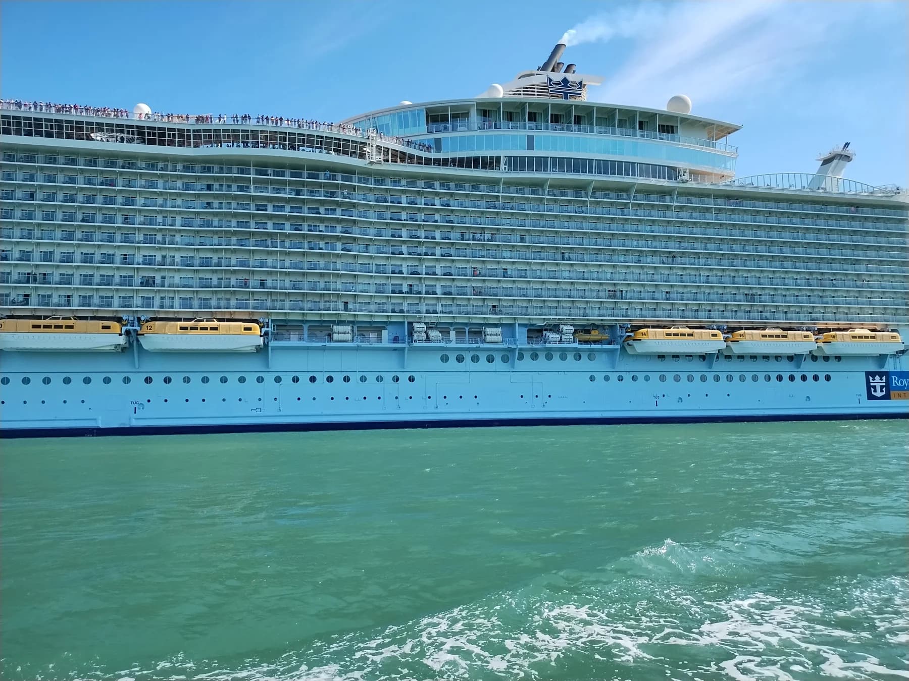 A cruise ship passing through the turquoise water of Port Canaveral